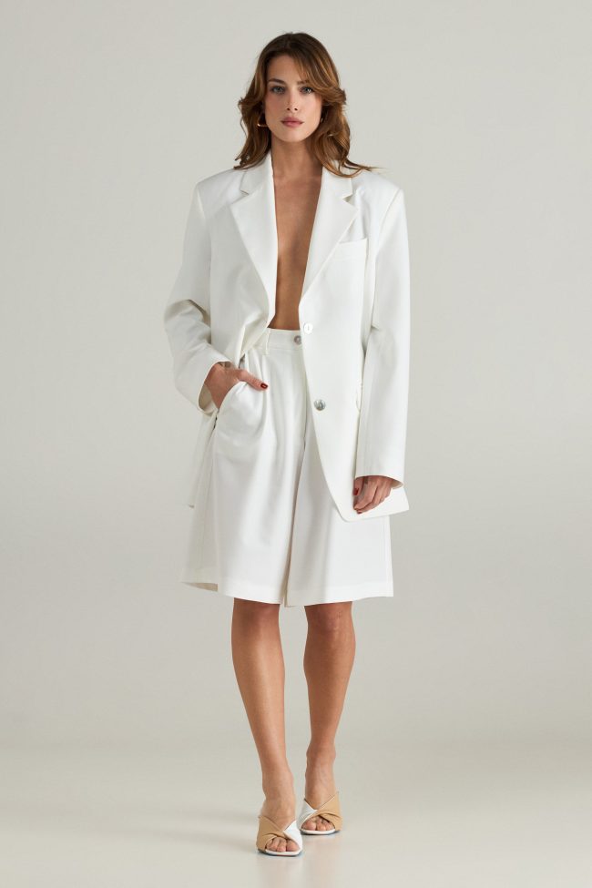Model wearing the Cortese off-white blazer styled with tailored shorts and minimal accessories