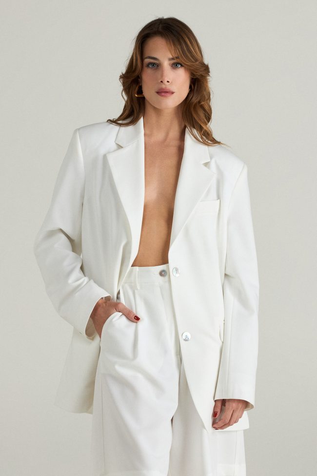 Model wearing the Cortese off-white blazer styled with tailored shorts and minimal accessories
