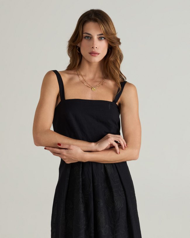 Model wearing black midi dress with wide straps, square neckline, and embroidered broderie anglaise hem.
