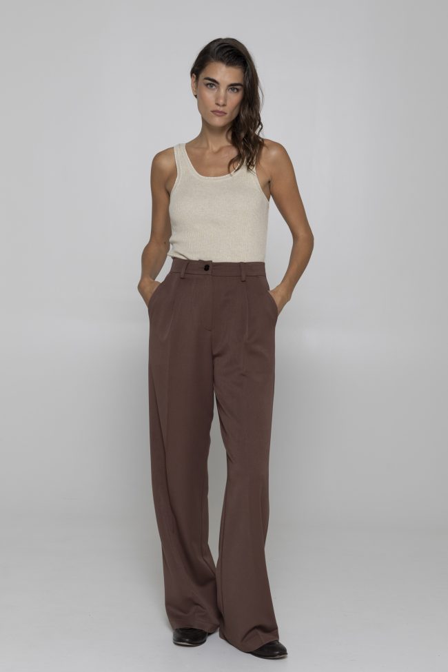 Model wearing chocolate brown wide-leg trousers with beige top